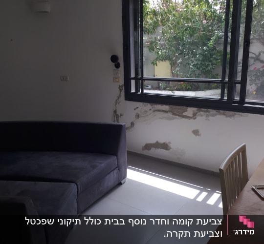 קיר עם קילופי צבע ליד חלון גדול